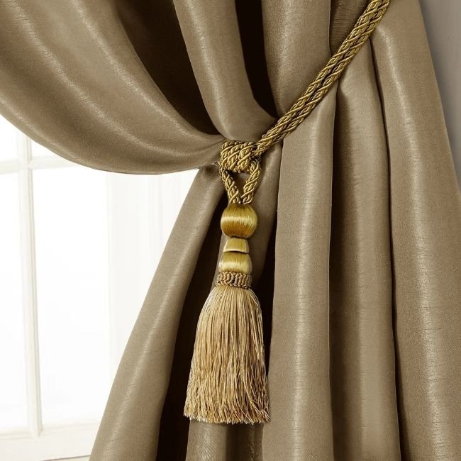 Gold-finish curtain tie-backs installed in home